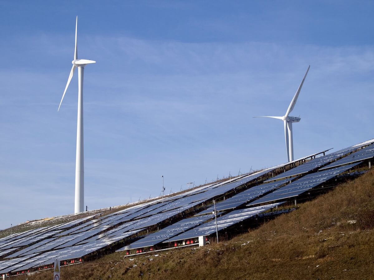 Solpaneler och vindkraftverk i vinterlandskap, fossilfri elproduktion i Sverige